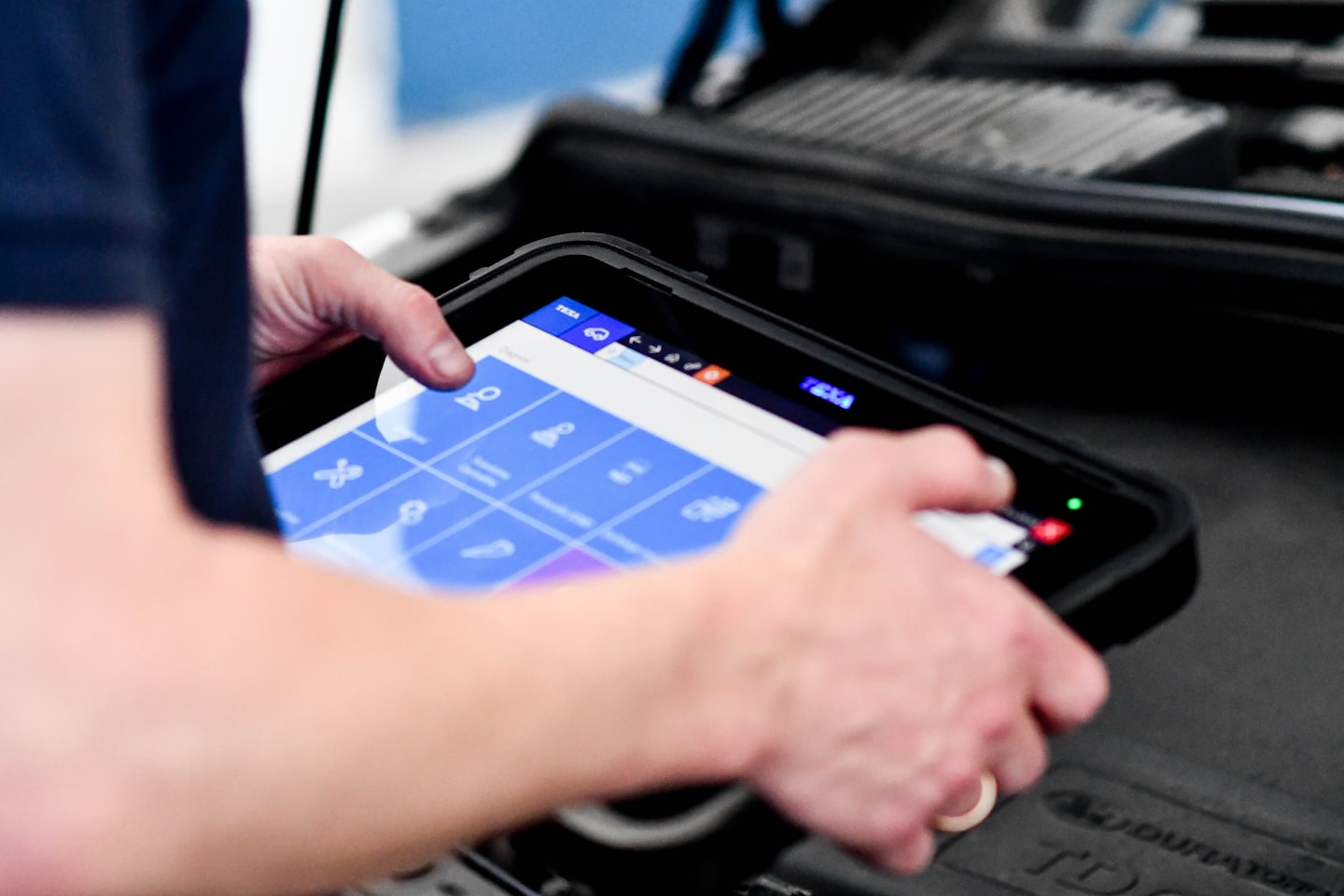 Ein Techniker diagnostiziert mit einem Tablet einen Motor.